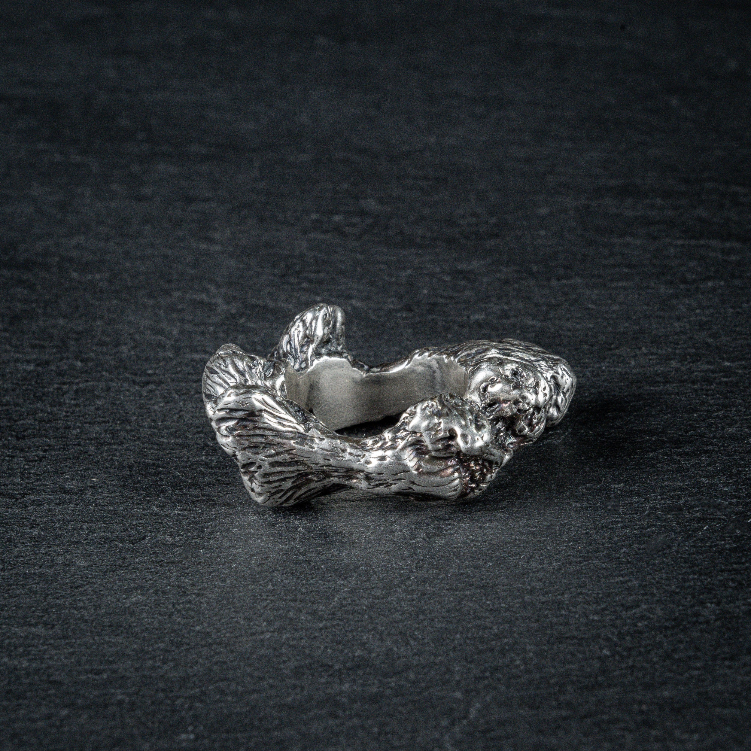 Side view of silver ring 'KUILUUN' – dramatic, abyss-inspired design with shadowed inner structure on slate
