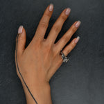 Sculptural oxidized silver ring 'Tephra' by Myon Rox – asymmetric open band, molten texture, unisex design, on hand. on slate