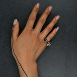 Sculptural oxidized silver ring 'Tephra' by Myon Rox – asymmetric open band, molten texture, unisex design, on hand. on slate