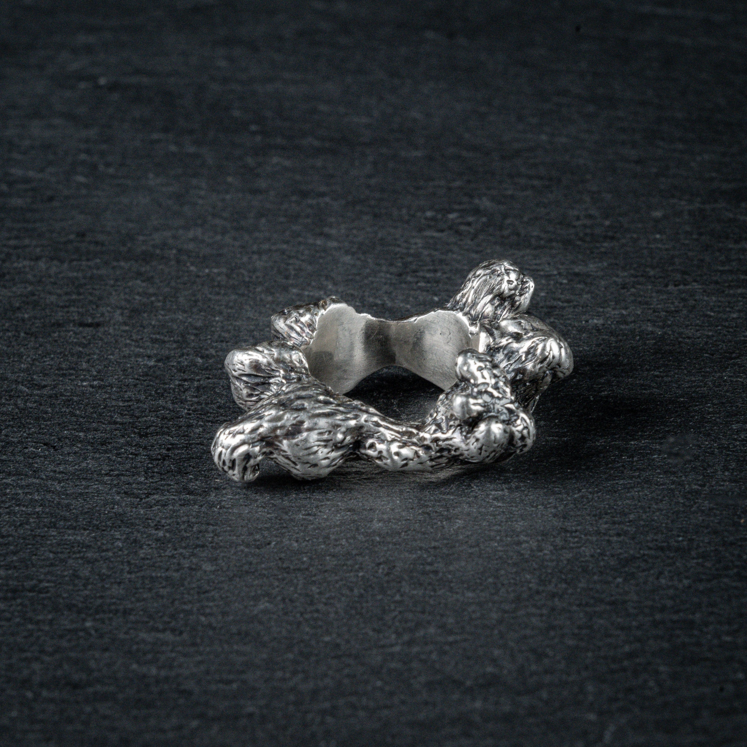 Side view of silver ring 'KUILUUN' – dramatic, abyss-inspired design with shadowed inner structure