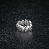 ASCEY silver ring with bold jagged spine-inspired design on dark slate, front viewASCEY silver ring with bold jagged spine-inspired design on dark slate, front view