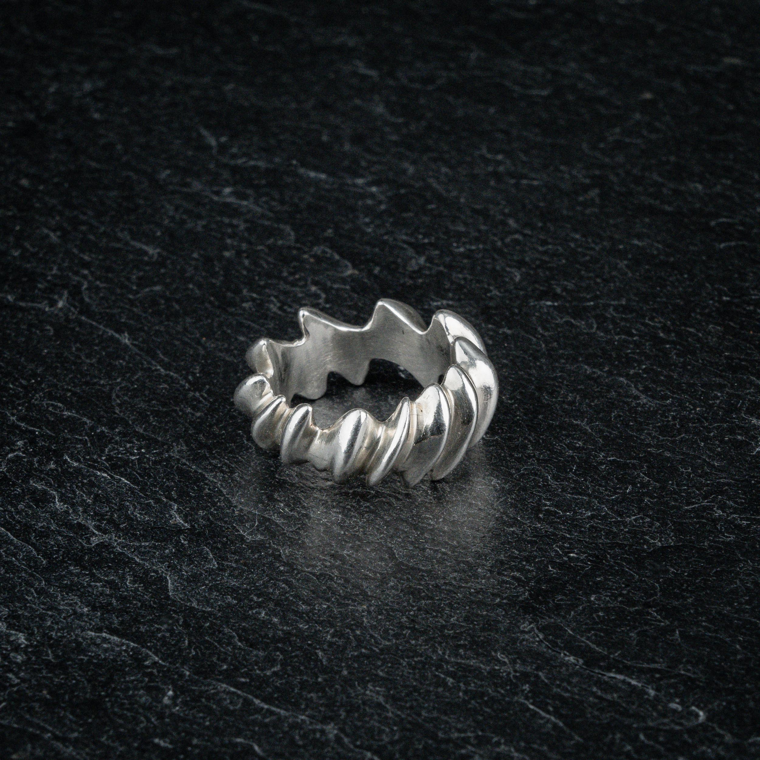 ASCEY silver sculptural ring with bold jagged spine design on dark slate, top viewASCEY silver sculptural ring with bold jagged spine design on dark slate, top view