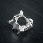 SYRINX organic massive silver sculptural statement ring on dark slate, top view