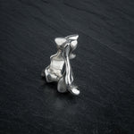 SYRINX organic massive silver sculptural statement ring standing on dark slate, back view