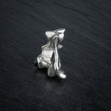 SYRINX organic massive silver sculptural statement ring standing on dark slate, back view