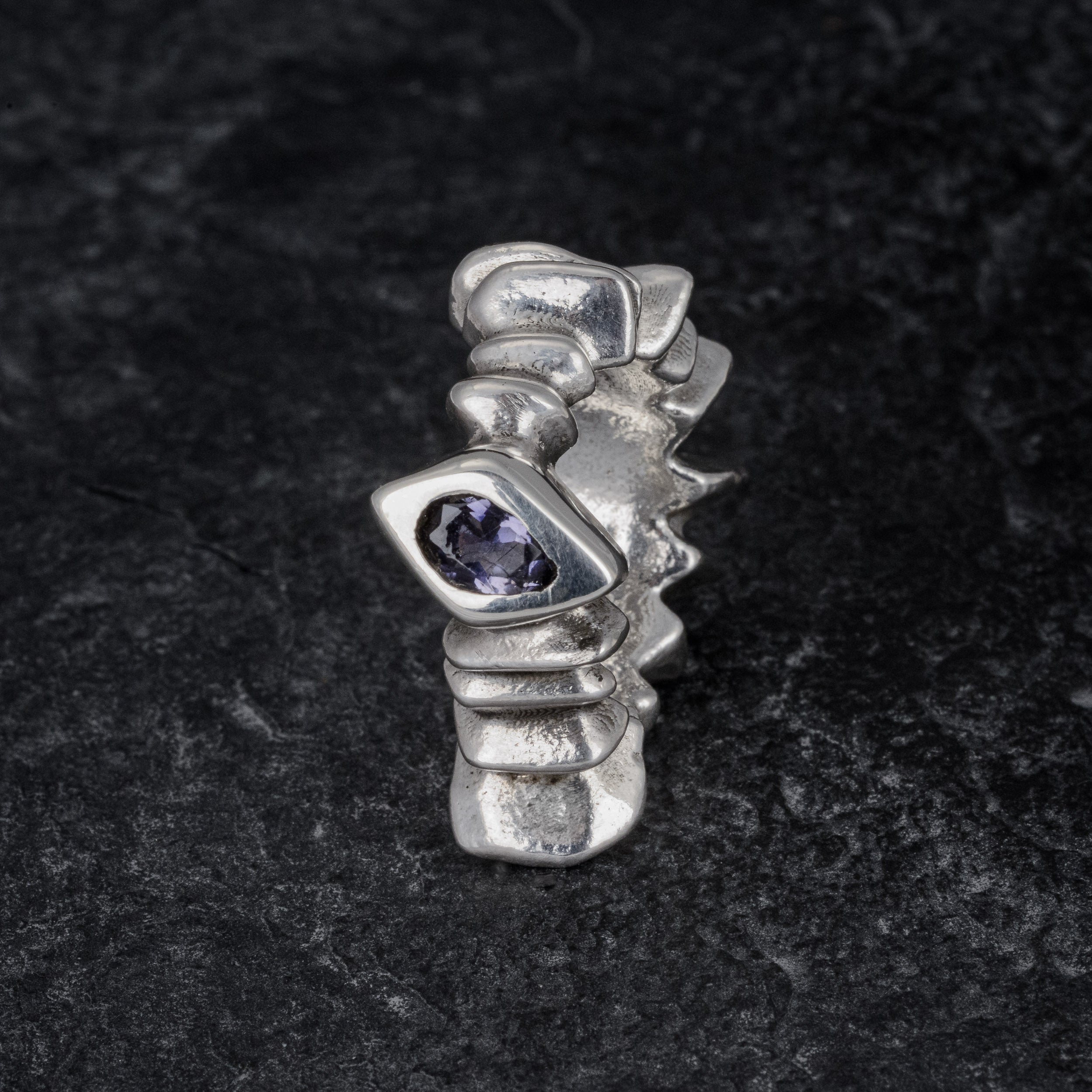 TRANSIT massive silver ring with stepped pattern and central iolite gemstone on slate, front view