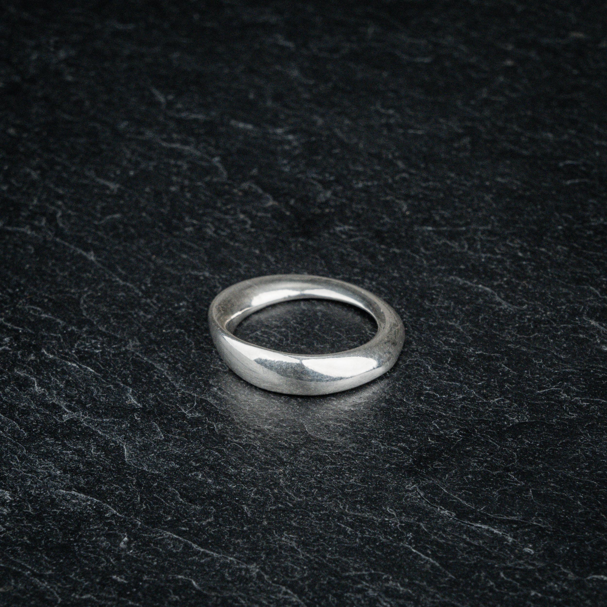 TRI_M18 single silver Möbius strip ring featuring 180 degree twist, solo on slate
