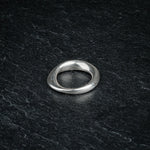 TRI_M36 single silver Möbius strip ring featuring 360 degree twist, solo on slate