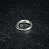 TRI_M36 single silver Möbius strip ring featuring 360 degree twist, solo on slate