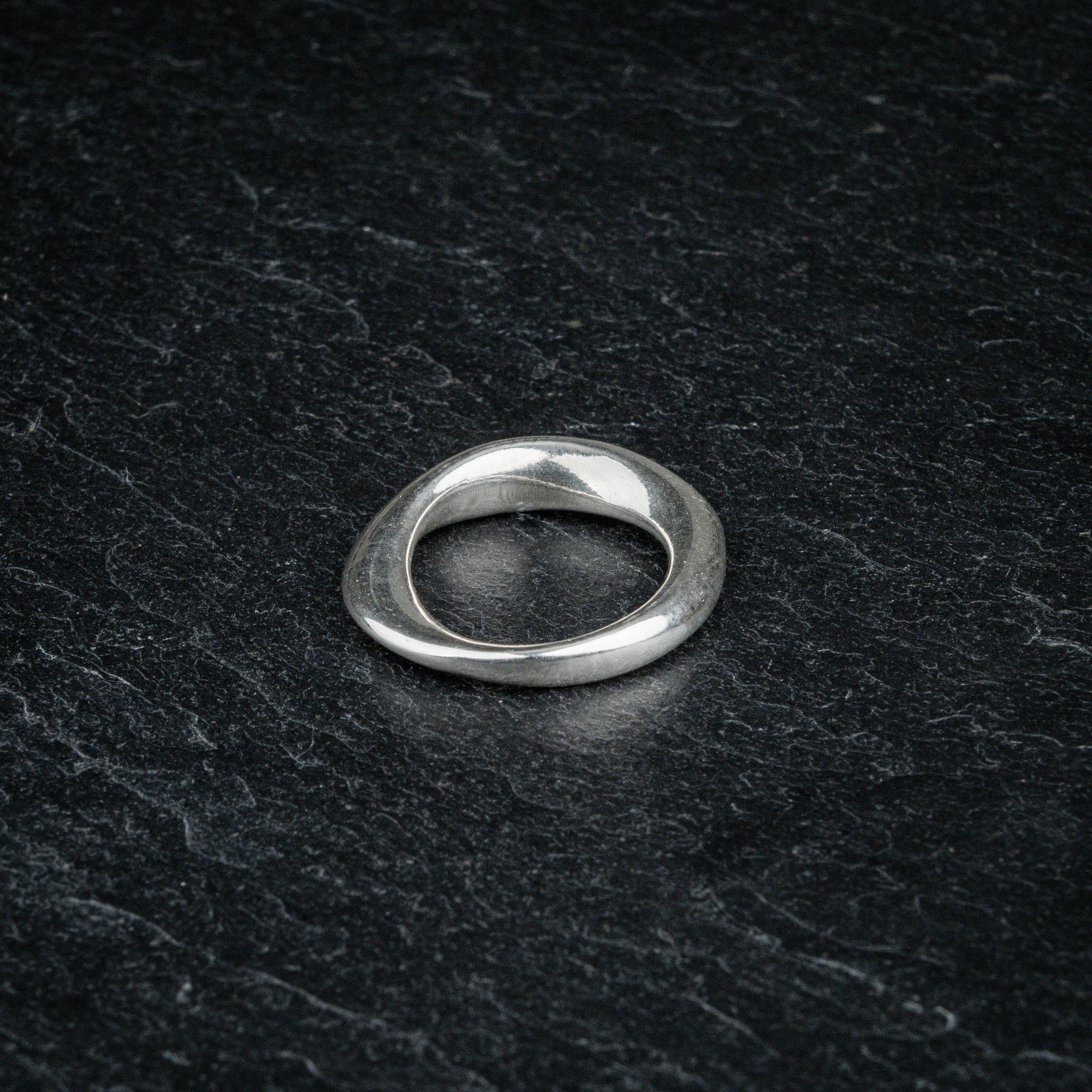 TRI_M36 single silver Möbius strip ring featuring 360 degree twist, solo on slate