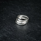 TRI_M three stackable silver Möbius strip rings stacked on top of each other on slate