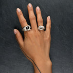 YUHI two massive silver sculptural rings evoking sunrays with onyx and moonstone worn on hand