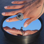 PHI worn as silver ring on hand, then spinning as kinetic sculpture on mirror base